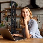 Smiley young girl with a laptop _ Free Photo